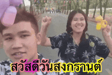 a man and a woman are standing next to each other with the words " สวัสดี วัน สงกรานต์ " written on the bottom
