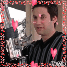 a man with hearts on his face is holding a gun in a picmix frame