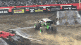 monster truck racing on a dirt track with a banner that says the video game