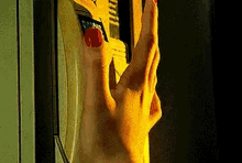 a woman 's hand with red nails is reaching out towards a telephone .