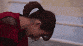 a woman with a ponytail on her head looks down