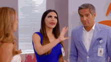 a woman in a blue dress talks to a man in a suit