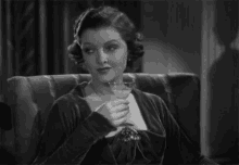 a woman is sitting in a chair holding a glass of wine