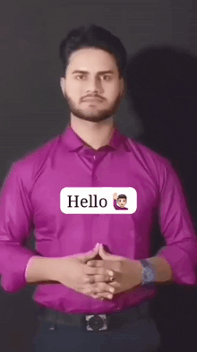 a man in a purple shirt says hello with an emoji on his chest