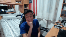 a man wearing headphones sits in front of a bed