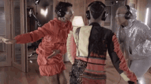 a woman wearing headphones is dancing with two other people