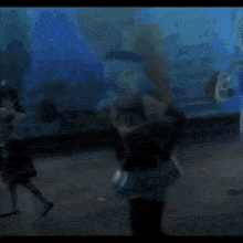 a girl with blue hair and black gloves is standing in a dark room