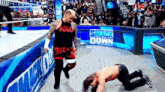 two men are wrestling in a wrestling ring with a sign that says smack down in the background