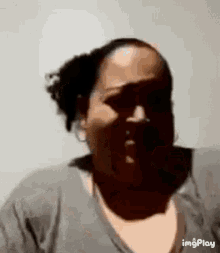 a woman is making a funny face with her mouth open in a close up .