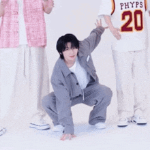 a man in a phyps jersey is squatting down on the floor