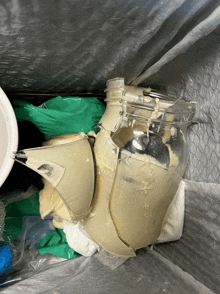 a broken jar filled with a creamy substance sits in a plastic bag