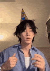 a young man wearing a birthday hat is making a funny face .