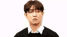 a young man wearing glasses and a black shirt