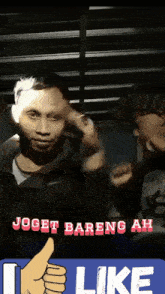 a man giving a thumbs up in front of a sign that says joget bareng ah