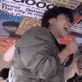 a man singing into a microphone with a poster that says " who cares " behind him