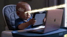 a baby is sitting in a high chair holding a tablet and a laptop .