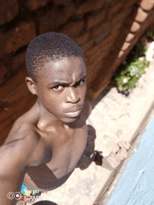 a man without a shirt is taking a selfie with a phone that says spark on it