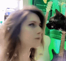 a blurry picture of a woman and a cat with guitars in the background