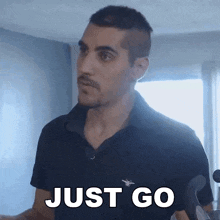 a man in a black shirt says just go in white letters