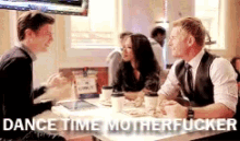 a group of people are sitting at a table with the words dance time motherfucker on the bottom