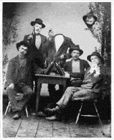 a group of men are posing for a picture with one man holding a mirror