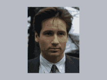 a close up of a man 's face with a suit and tie