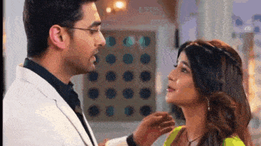 a man and a woman are standing next to each other and looking at each other .