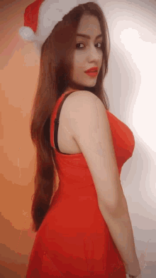 a woman in a santa hat and red dress