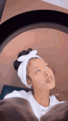 a woman with a headband on her head is looking up at the camera .