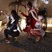 a group of people are squatting down in a room with a couch in the background