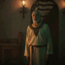 a man with a beard is standing in front of a candle