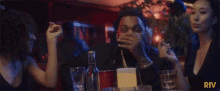 a group of people sitting at a table with the word riv in the corner