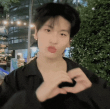 a young man making a heart with his hands