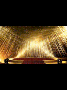 a stage with a red carpet and gold lights coming out of the ceiling