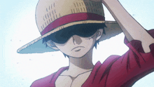 a man wearing a straw hat and sunglasses holds his hand to his forehead