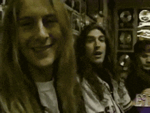 a group of people are standing next to each other in a dark room and smiling .