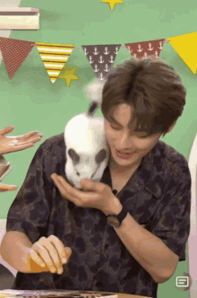 a man holding a small white rabbit in his hands