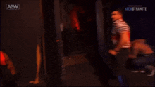 a couple of men are standing next to each other in a dark room with the aew logo on the bottom