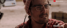 a man with glasses and a bandana on his head has a youtube channel called astroshow behind him