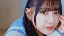 a close up of a girl 's face with a hand on her face