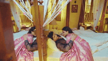 a man and a woman are laying on a bed with a canopy