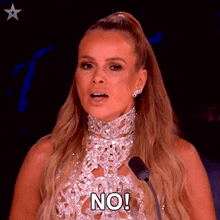 a woman speaking into a microphone with the words no on her chest