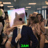 a man in a suit and tie is holding a picture of a cat in front of his face and says jam