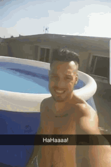 a shirtless man is standing in front of an inflatable pool that says haaaa on it