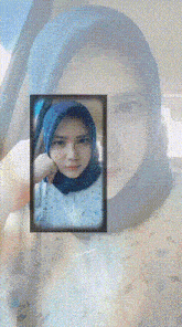 a woman wearing a hijab is taking a picture of herself in a car