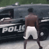 a man is dancing in front of a police car