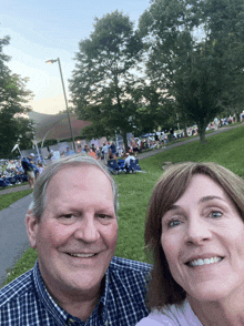 a man and a woman are posing for a picture in front of a crowd