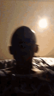 a blurry photo of a person 's head with a light behind them