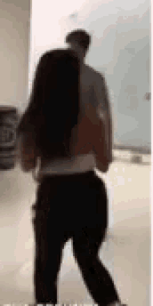 a man and a woman are standing next to each other in a hallway .