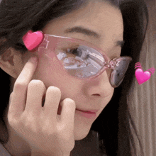 a woman wearing a pair of pink sunglasses with pink hearts on them